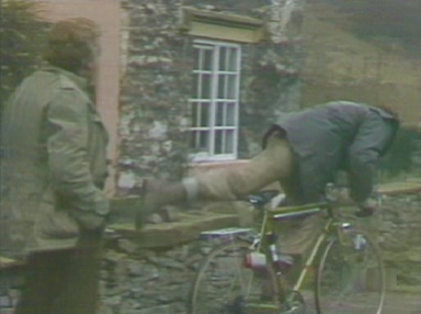 Charles mounts the bike, and pedals away