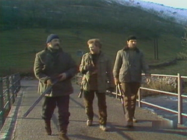 Sanders, Phil and Jim walk across the bridge warily as the dogs scatter